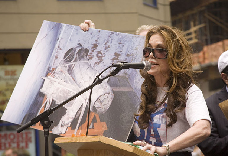 Pamela Geller organizer of June 6 rally holds photo of plane parts