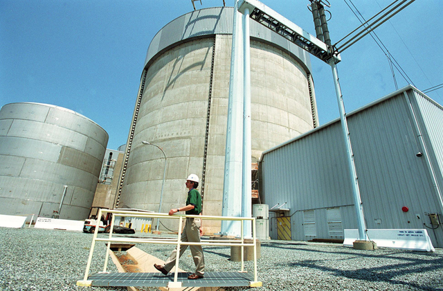 Karl Neddenien walks across a bridge over ditches that isolate the plant from the envirionment and drain rain water in front of the one of two reactor containment buildings at the Calvert Cliffs Nuclear Power Plant in Calvert County, MD.  Photo taken May 30, 2001. ( Mary F. Calvert / The Washington Times)