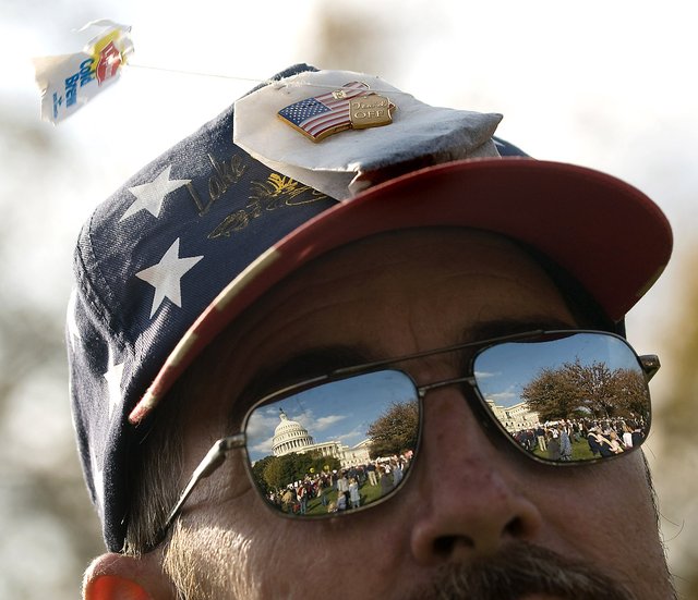 With a tea bag on his hat and the Capitol reflected in his glasses, Paul Nelson of Edgewater, Md., joins members of the Tea Party Express rally Thursday at the Capitol to show their opposition to Democratic health care reform plans. (Allison Shelley/The Washington Times)
