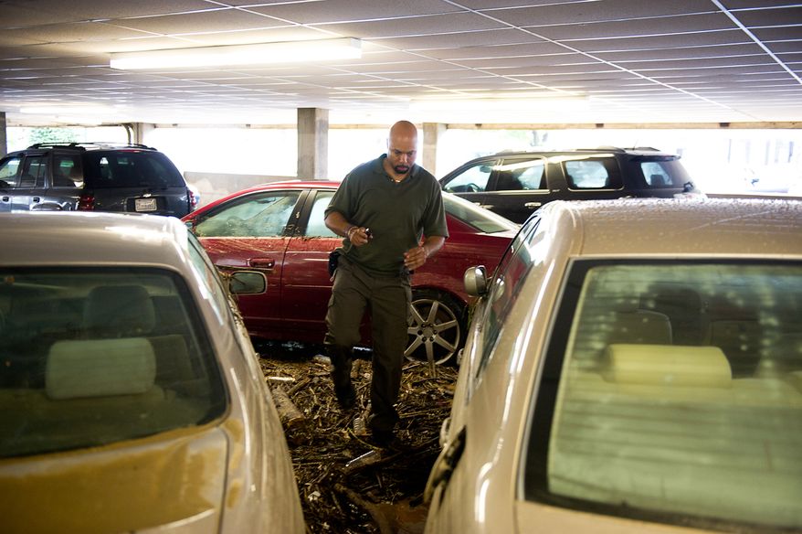 William Borden looks at the flood damage to his Lexus in the parking lot of Strayer University in Alexandria, Va., on Sept. 9, 2011. The lot was flooded after heavy rains pounded the region the previous night. (Andrew Harnik/The Washington Times)