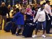 Passengers from the disabled Carnival Triumph cruise ship arrive by bus at the Hilton Riverside Hotel in New Orleans, Friday, Feb. 15, 2013. The ship had been idled for nearly a week in the Gulf of Mexico following an engine room fire. (AP Photo/Gerald Herbert)