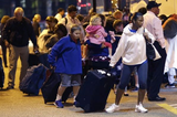 Passengers from the disabled Carnival Triumph cruise ship arrive by bus at the Hilton Riverside Hotel in New Orleans on Friday, Feb. 15, 2013. The ship had been idled for nearly a week in the Gulf of Mexico following an engine-room fire. (AP Photo/Gerald Herbert)