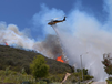 A helicopter makes a water drop on flames as a wildfire burns along a hillside in Thousand Oaks, Calif., Thursday, May 2, 2013. A Ventura County Fire Department spokeswoman said the blaze that broke out Thursday morning near Camarillo and Thousand Oaks, 50 miles west of Los Angeles, had spread to over 6,500 acres, forcing evacuations of nearby neighborhoods. (AP Photo/Mark J. Terrill)